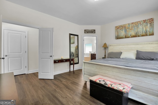 bedroom featuring dark wood-style floors, connected bathroom, and baseboards