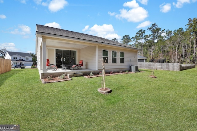 rear view of property with central air condition unit, a patio area, fence, and a lawn