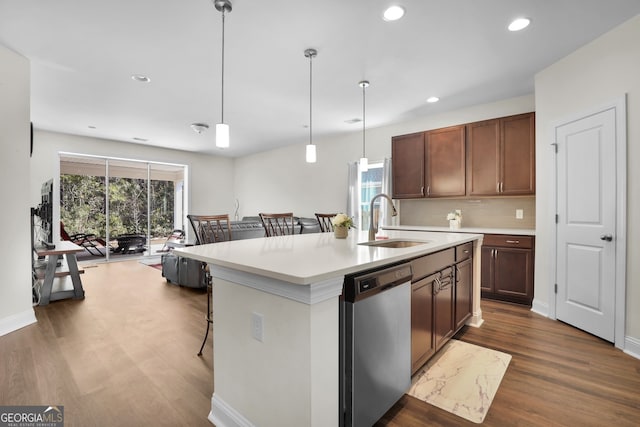 kitchen featuring dark wood-style floors, light countertops, stainless steel dishwasher, a sink, and recessed lighting