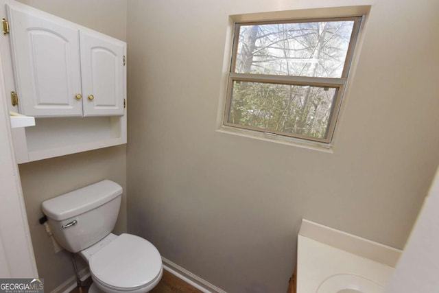 bathroom featuring baseboards and toilet