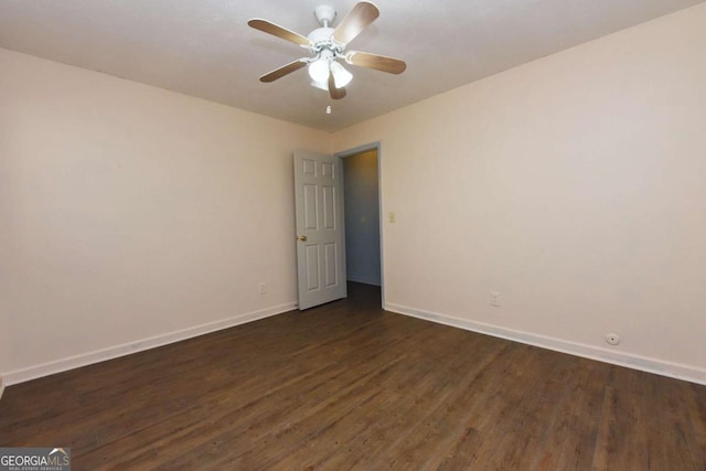 spare room featuring dark wood-style floors, ceiling fan, and baseboards