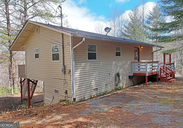 exterior space with stairs, crawl space, and a wooden deck