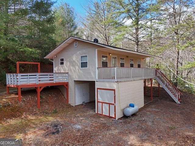 rear view of property featuring stairs and a deck