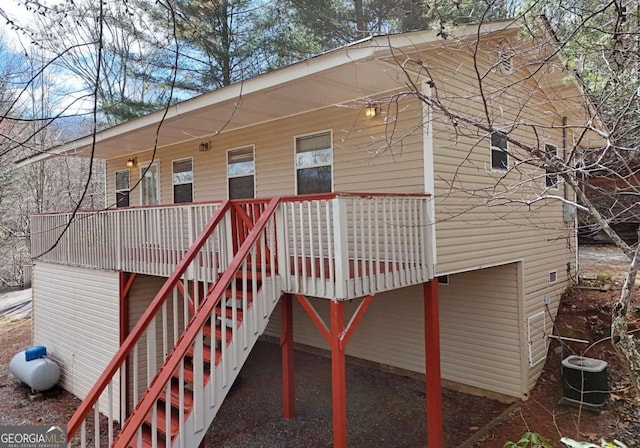 back of property featuring covered porch, central AC, and stairway