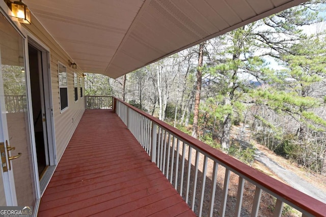 wooden terrace featuring a forest view