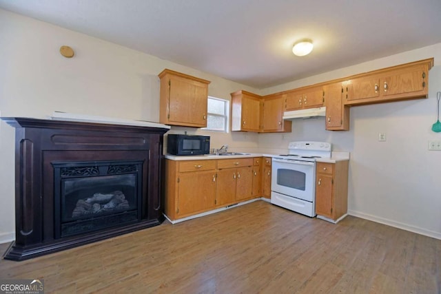 kitchen featuring white electric stove, black microwave, under cabinet range hood, a sink, and light countertops