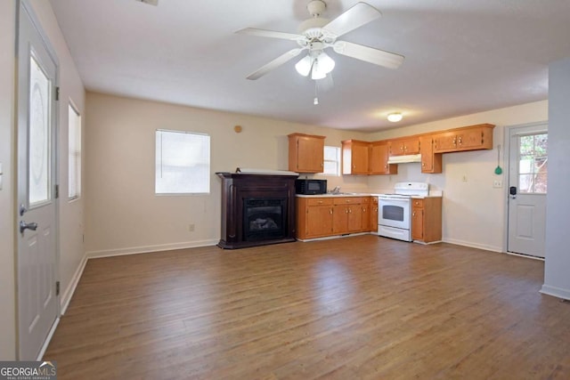 kitchen featuring black microwave, light countertops, electric range, and dark wood-style flooring