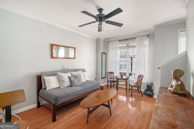 living room with baseboards, ceiling fan, wood finished floors, and crown molding