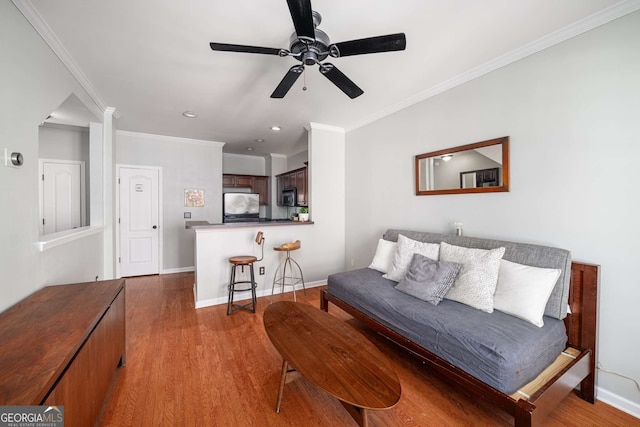 living area with ceiling fan, recessed lighting, wood finished floors, baseboards, and ornamental molding