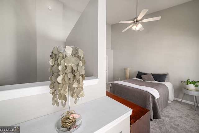 carpeted bedroom with ceiling fan and a high ceiling