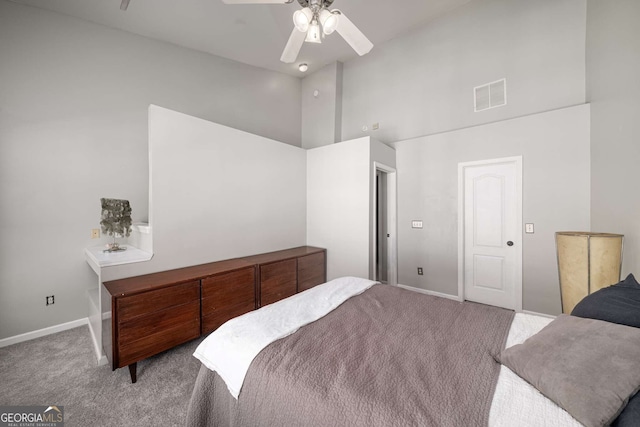 carpeted bedroom with high vaulted ceiling, baseboards, visible vents, and a ceiling fan