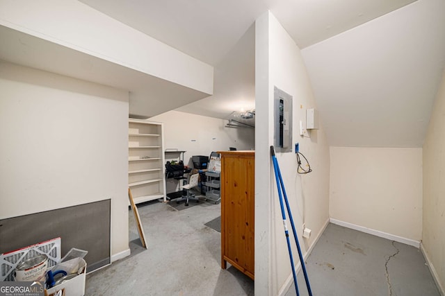 additional living space featuring concrete flooring, lofted ceiling, electric panel, and baseboards