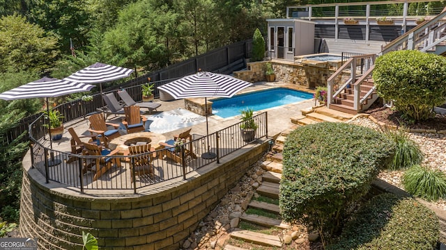 view of swimming pool featuring a fenced backyard, a fire pit, a fenced in pool, a patio, and stairs