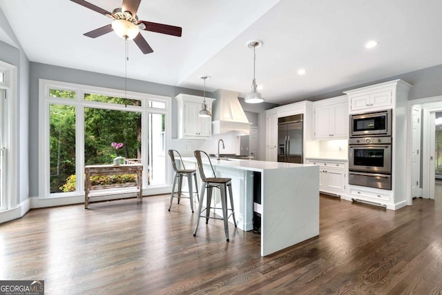 kitchen featuring a warming drawer, a ceiling fan, a sink, built in appliances, and custom exhaust hood