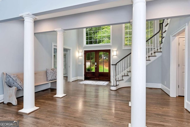 foyer featuring baseboards, stairway, wood finished floors, french doors, and ornate columns