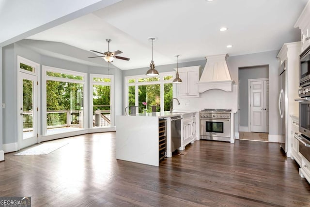 kitchen with premium range hood, a peninsula, a sink, light countertops, and appliances with stainless steel finishes