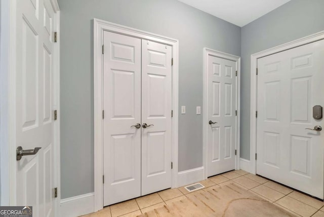 entryway featuring light tile patterned floors, visible vents, and baseboards