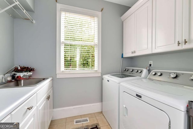 clothes washing area featuring visible vents, light tile patterned flooring, separate washer and dryer, cabinet space, and a sink