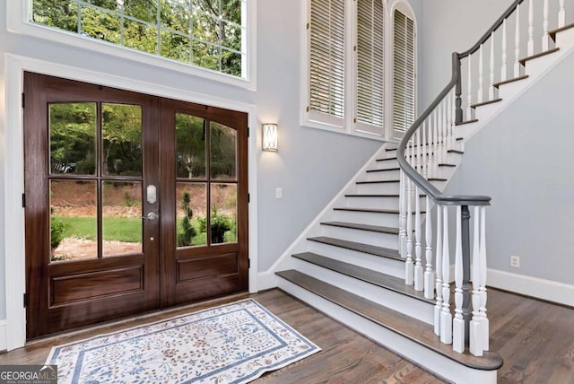 foyer featuring stairway, plenty of natural light, wood finished floors, and baseboards