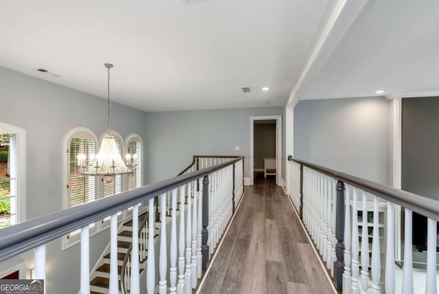 corridor with visible vents, wood finished floors, a notable chandelier, and recessed lighting