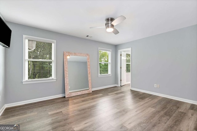 empty room featuring wood finished floors, ceiling fan, and baseboards