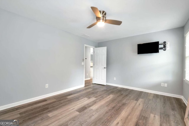 interior space with baseboards, dark wood-style flooring, and a ceiling fan