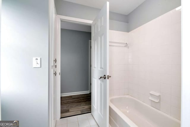 bathroom featuring baseboards, tile patterned flooring, and bathing tub / shower combination