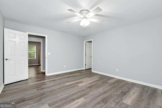 unfurnished bedroom featuring baseboards, wood finished floors, and a ceiling fan