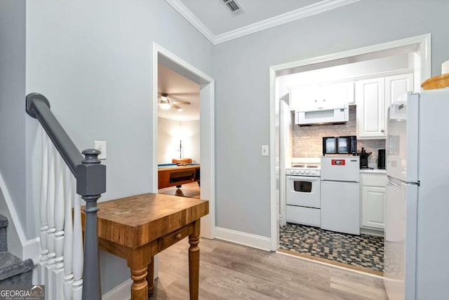 kitchen featuring white appliances, visible vents, white cabinets, crown molding, and backsplash