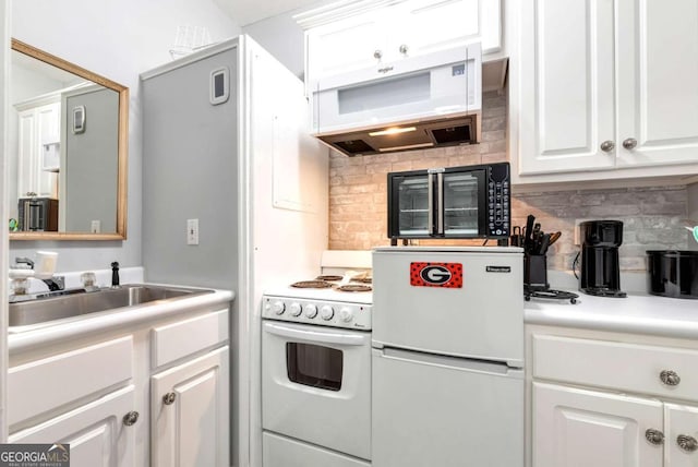 kitchen with white appliances, ventilation hood, light countertops, white cabinets, and backsplash