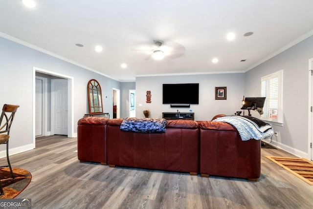 living area featuring baseboards, wood finished floors, and crown molding