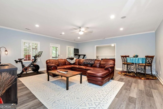 living area featuring visible vents, ceiling fan, baseboards, and wood finished floors