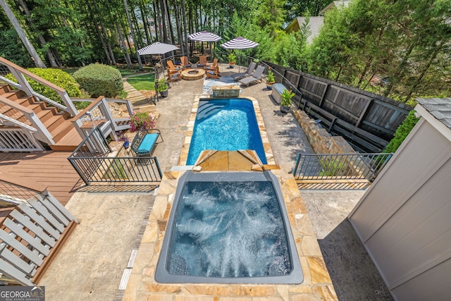 view of swimming pool with a fenced backyard, a fire pit, a fenced in pool, an in ground hot tub, and a patio area