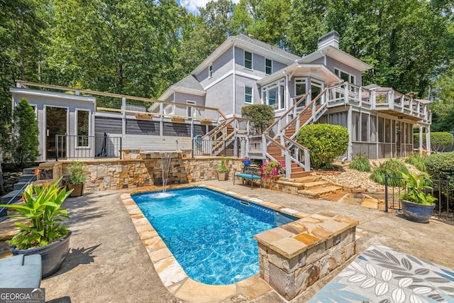 pool with stairway, a sunroom, and a patio area