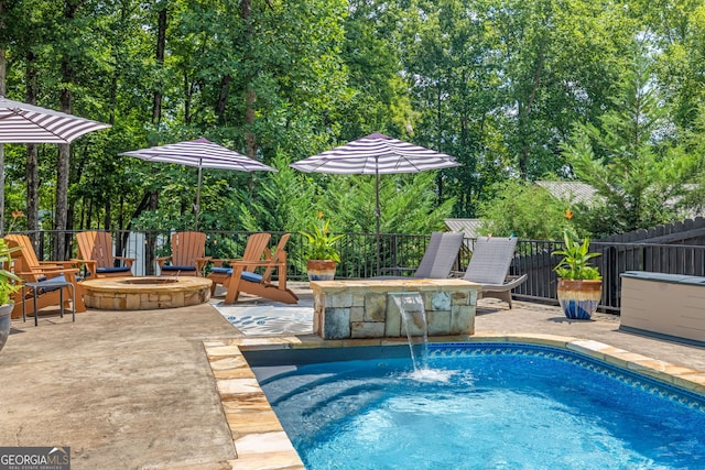 view of swimming pool featuring fence, a fire pit, a patio, and a fenced in pool