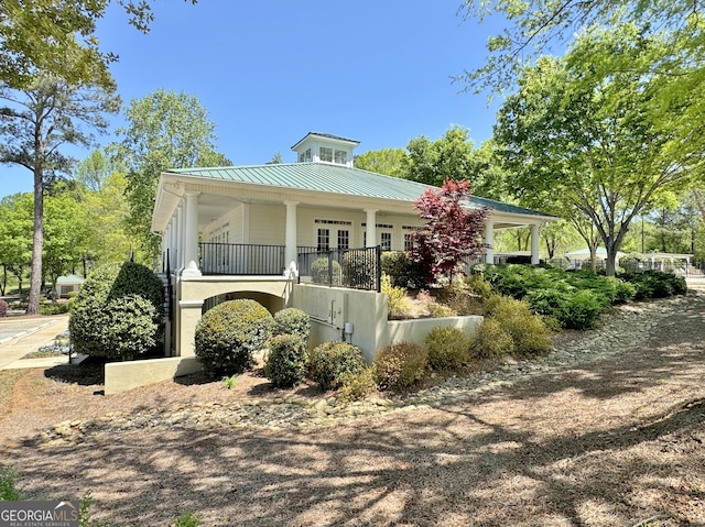 view of front facade featuring a standing seam roof, a porch, and metal roof