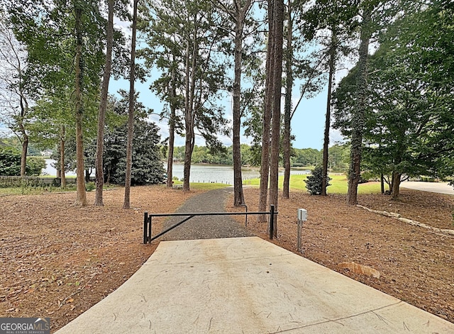 view of yard with concrete driveway and a water view