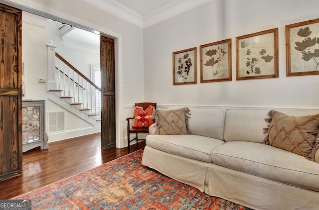 living area with visible vents, wainscoting, ornamental molding, wood finished floors, and stairs