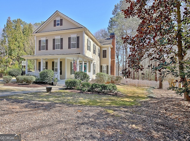 view of front of property with a porch, fence, and a chimney