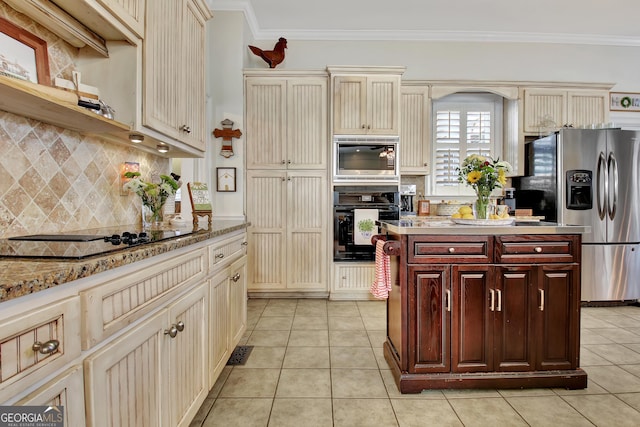 kitchen with black appliances, crown molding, light tile patterned floors, and cream cabinetry