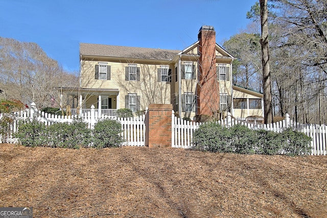 view of front of house with a fenced front yard and a chimney