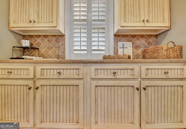 kitchen featuring light countertops, cream cabinets, and backsplash