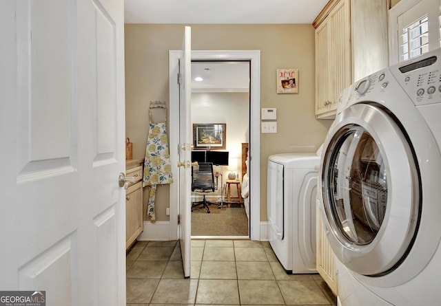 laundry room featuring cabinet space, light tile patterned floors, and washing machine and clothes dryer