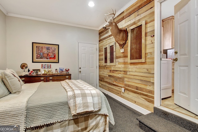 bedroom featuring light carpet, wooden walls, washer / clothes dryer, and crown molding