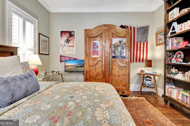 bedroom with ornamental molding, wood finished floors, and baseboards