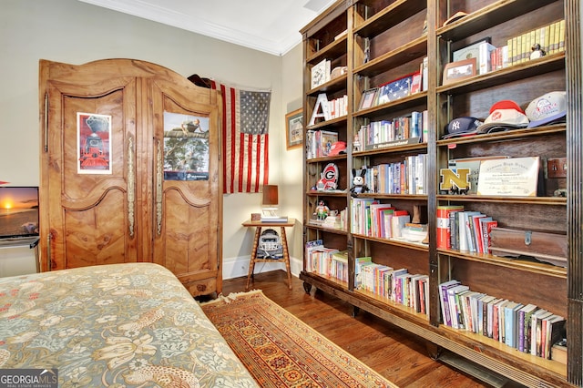 bedroom with baseboards, wood finished floors, and crown molding