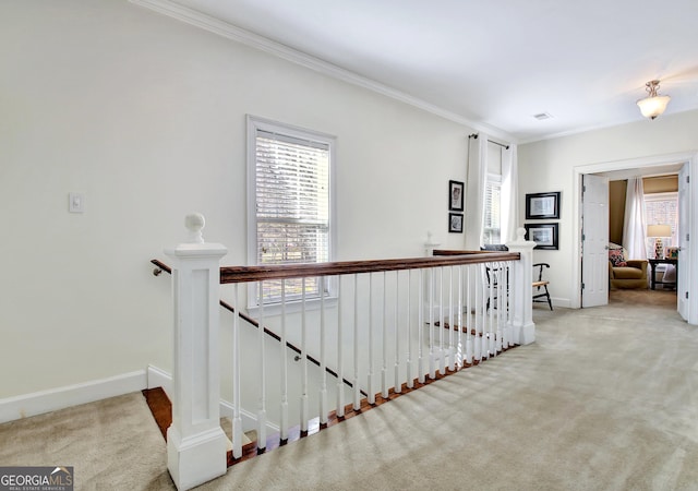 corridor featuring baseboards, carpet flooring, an upstairs landing, and crown molding