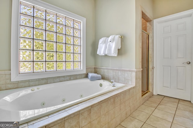 bathroom featuring a stall shower, tile patterned flooring, and a tub with jets