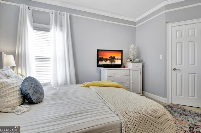 bedroom with ornamental molding and baseboards