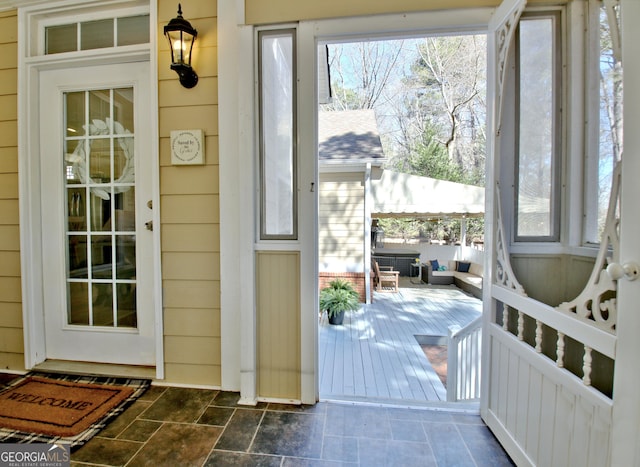 doorway featuring a sunroom and stone finish floor